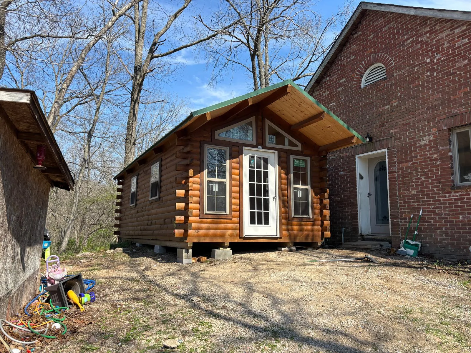 Log cabin set beside a brick home