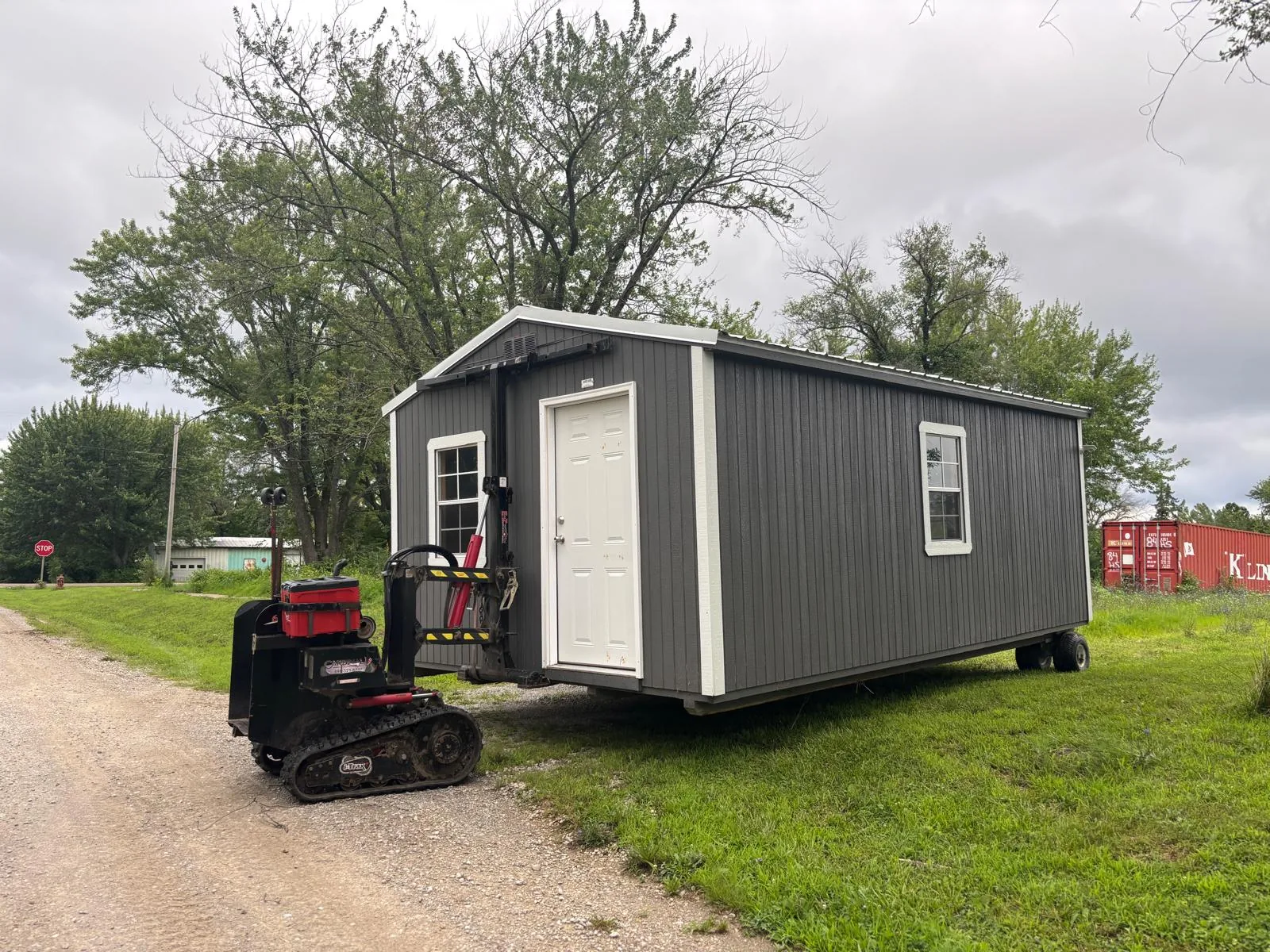 Portable shed being moved with specialized equipment