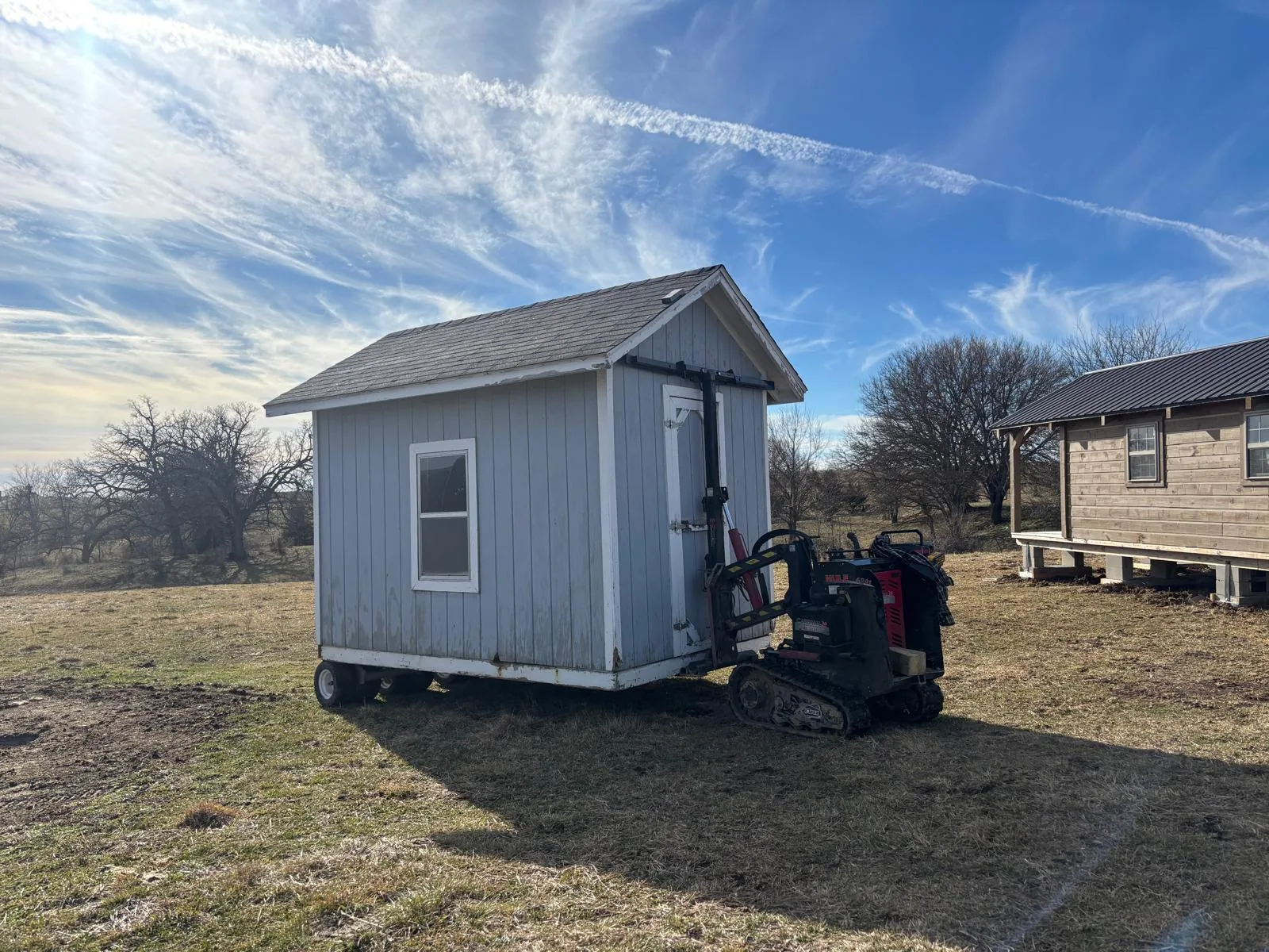 Small shed being moved across a field